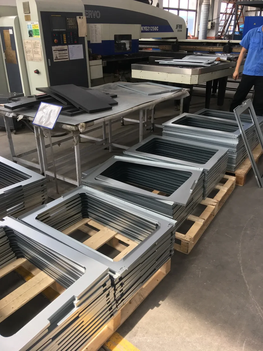 Batch of laser-cut sheet-metal cladding components beside the cutting equipment
