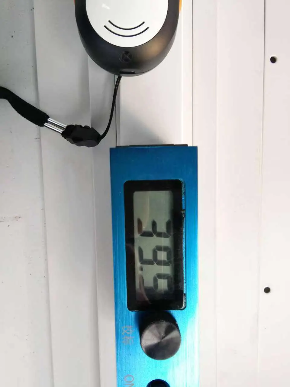 Gloss meter checking the surface of a powder-coated aluminum extrusion