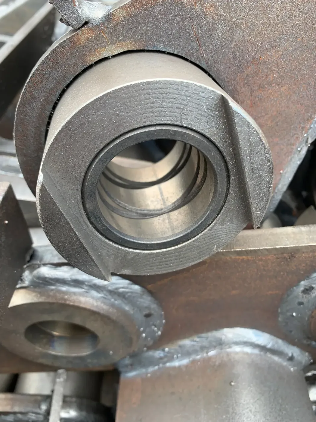 Close view of a press-fit bushing interface in a heavy-equipment attachment