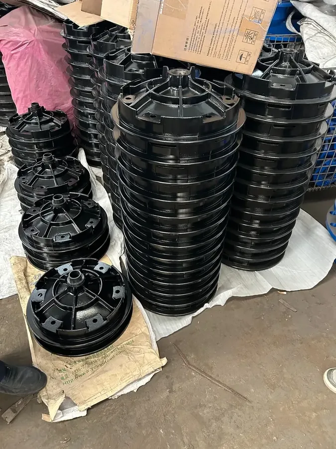 Black coated cast iron housing components stacked for shipment